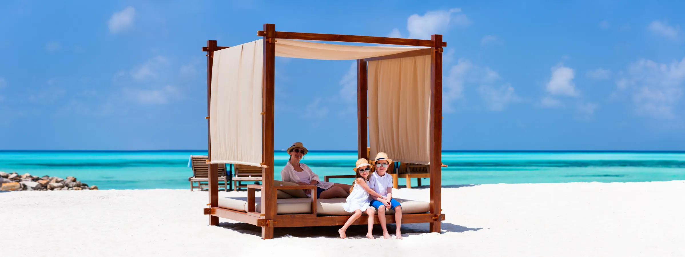 A family relaxing at a beach cabana